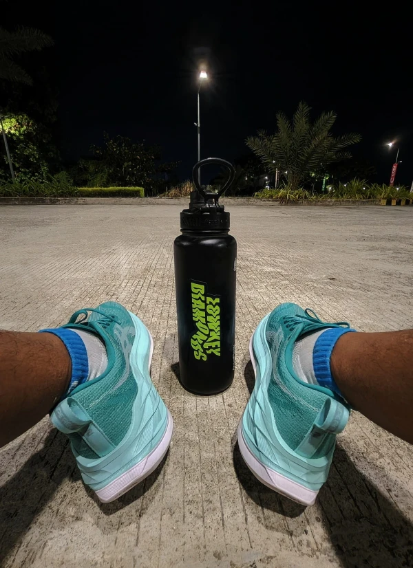 A person sitting next to a black water bottle.
